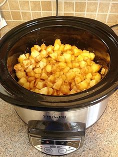 a crock pot filled with potatoes sitting on top of a counter