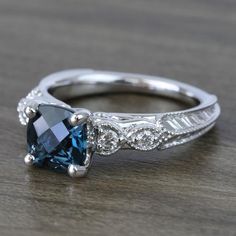 a blue and white diamond ring on top of a wooden table