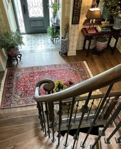 the stairs lead up to an entryway with a rug on the floor and potted plants