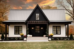 a black and white house with pumpkins on the front steps, trees in the background