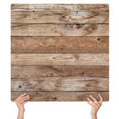 two hands are holding up a wooden paneled wall with wood planks on it