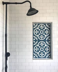 the shower head is next to a tiled wall