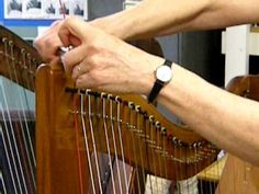 a person is holding the strings of a harp