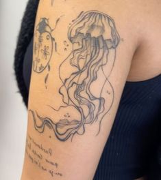 a woman with a tattoo on her arm has a jellyfish in it's mouth