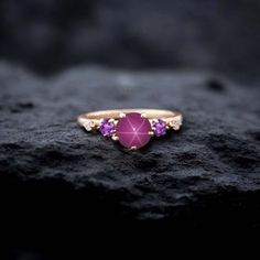 a gold ring with an amethorate and purple stones on top of it