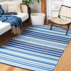 a blue and white rug in a living room next to a couch with a chair