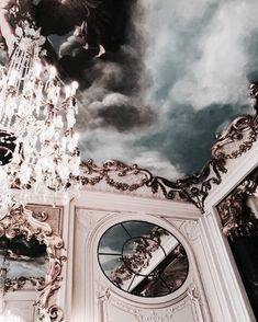 a chandelier hanging from the ceiling in front of a painting on the wall