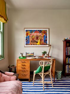 a room with a desk, chair and bookshelf on the wall next to a window