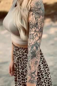 a woman with long blonde hair and tattoos on her arm is posing for the camera