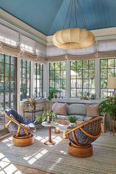 a living room filled with lots of furniture and windows covered in blue tint coverings