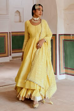 Yellow A-line flare anarkali made in chanderi base with potli buttons. Paired wit a flared skirt with a zari hemline border. Comes along with an embroidered dupatta.
Components: 3
Pattern: Placement Embroidery
Type Of Work: Zari, Thread
Neckline: Round Neck
Sleeve Type: Full Sleeves
Fabric: Anarkali: Chanderi, Skirt: Cotton Crepe, Dupatta: Embroidered Georgette
Color: Yellow
Other Details: 
Attached lining
Gota patti embroidered cuffs
Box pleated flare
Scallop laced, trellis embroidered dupatta Lace Suit Design, Palm Spring Wedding, Pre Wedding Dresses, Trending Maxi Dresses, Chanderi Anarkali, Yellow Anarkali, Ridhi Mehra, Placement Embroidery, Yellow Outfits