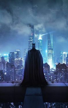 a batman standing on top of a building with the city lights in the background at night