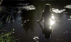 a woman sitting in the water at night