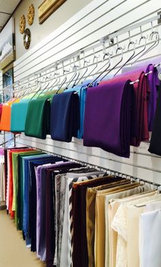 there are many different colored shirts hanging on the rack