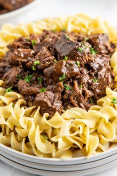 beef and noodles in a bowl with parsley on the side, ready to be eaten