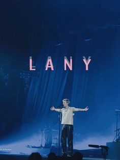 a man standing on top of a stage in front of a blue background with the word lany