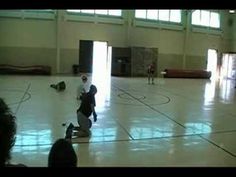 two men are playing basketball in an indoor gym