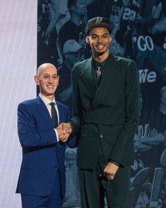 two men standing next to each other shaking hands