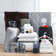 a pile of blankets and pillows sitting on top of a wooden floor