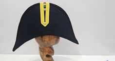 Napoleon Bicorne with black Trim Step into the history with the distinctive military headgear, Napoleon Bicorne with black Trim hat. It features the following characteristics: 1- Shape: The cap has a tall, crescent shape with a semi-circular top , characteristic of bicorne used by various military units, particularly during the 19th century. 2- Color: The primary color of the cap is black. 3- Emblem/Badge: The front of the cap displays a tricolor cockade,  green, white, and red, which indicate n Black Military Brimmed Hat, Black Brimmed Military Hat, Black Hat With Short Brim For Ceremonial Use, Black Short Brim Ceremonial Hat, Black Ceremonial Hat With Short Brim, Black Short Brim Hat For Ceremonial Use, Black Short Brim Hat For Ceremonial Occasion, Black Brimmed Hat For Ceremonial Occasions, Black Ceremonial Costume Hat With Curved Brim