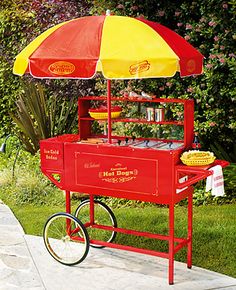 a hot dog cart with an umbrella on the top and two buns under it