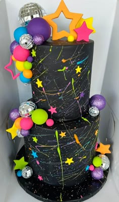 a three tiered cake decorated with stars and confetti