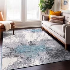 a living room area with a couch, chair and rug in front of a window