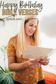 a woman holding a piece of paper with the words happy birthday bible verses on it