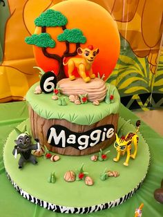 a birthday cake with lion and giraffe on top