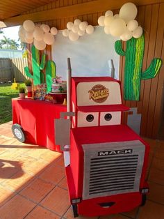 a birthday party with cars made out of cardboard boxes and balloons hanging from the ceiling