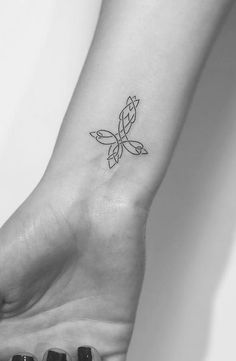 a black and white photo of a small tattoo on the wrist that has a butterfly