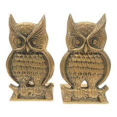 two gold owl figurines sitting next to each other on top of a white background