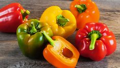 three different colored peppers sitting next to each other