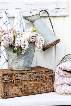 a basket with flowers sitting on top of a table next to a lamp and blanket