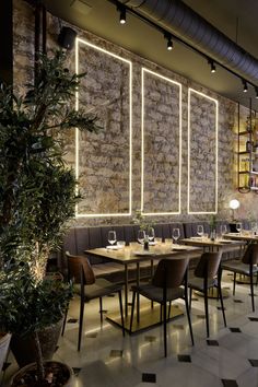 an empty restaurant with tables and chairs in front of a wall that has lights on it