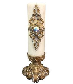 an ornate candle holder with a white pillar