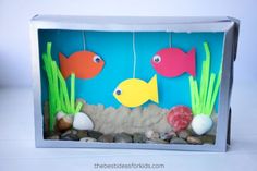 an aquarium made out of paper with fish and seaweed