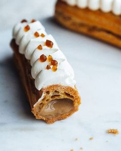 a piece of cake with icing and nuts on it sitting next to another slice