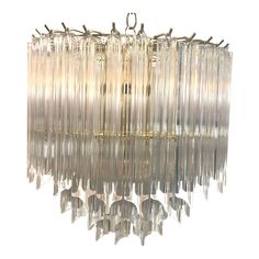 a large chandelier hanging from the ceiling with clear glass rods and metal fittings