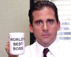 a man holding a coffee mug with the words world's best boss on it