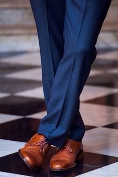 a man in a suit and tie standing on a black and white checkered floor