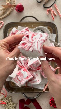 candy cane marshmallows on a tray surrounded by christmas decorations and other crafting supplies