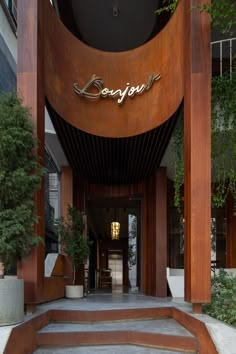 the entrance to an upscale hotel with steps leading up to it and plants growing on either side