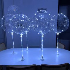 three lighted glass balls sitting on top of a table