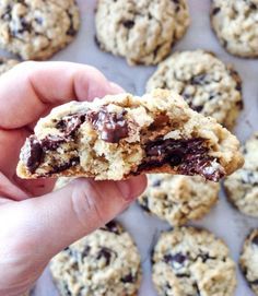 a person holding up a chocolate chip cookie