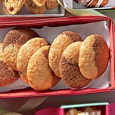 there are many different types of pastries in the box on the table, including donuts and muffins