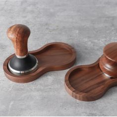 two wooden objects with black knobs on them sitting on the cement floor next to each other