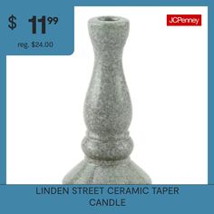 a white candle holder sitting on top of a table next to a blue sign that says linden street ceramic taper candle