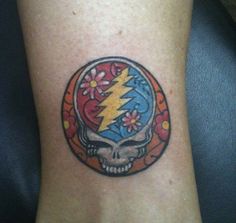 a tattoo on the leg of a person with a skull and lightning bolt in it