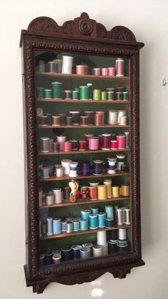 an old wooden shelf filled with lots of spools of thread